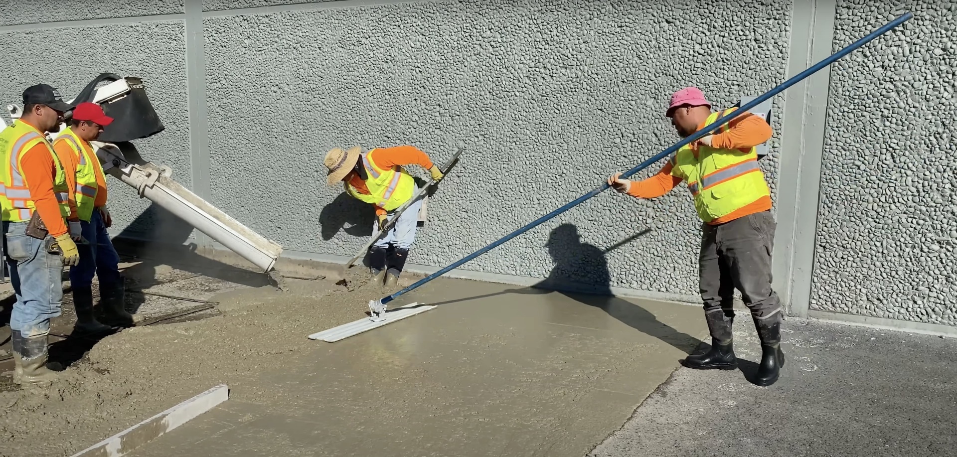 Professional concrete workers using specialized finishing equipment for high-quality results