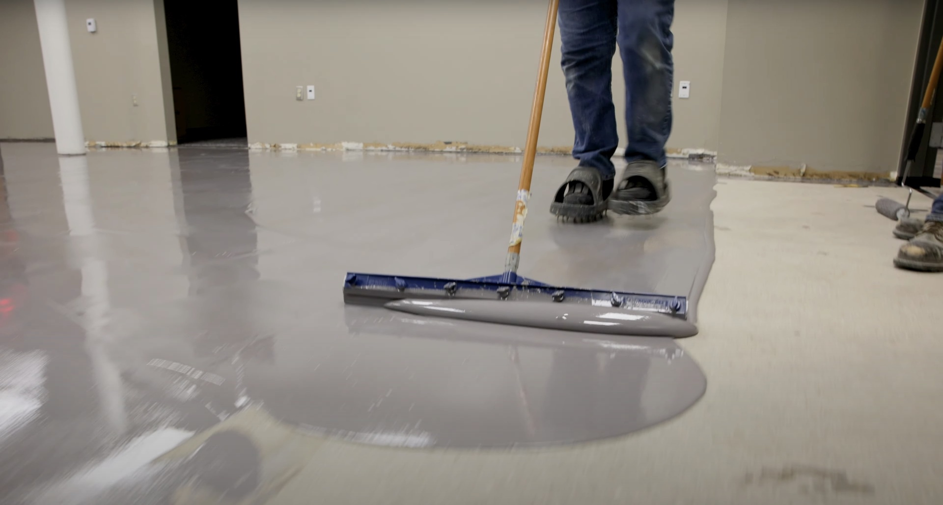 Professional concrete floor finishing with specialized equipment for smooth, level surfaces